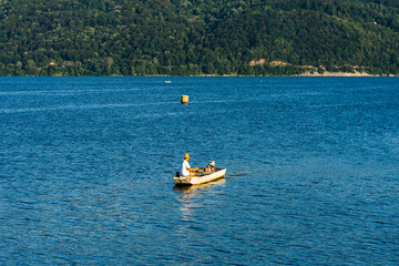 Fototapeta na wymiar Man in boat relaxing and fishing on Danube river on a sunny day in Orsova, Romania, 2020.