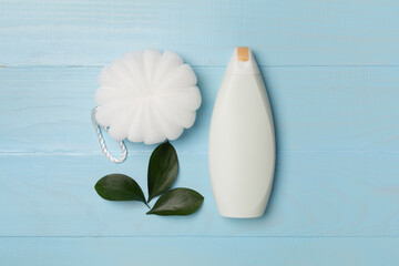 Shower gel with washcloth on wooden background, top view