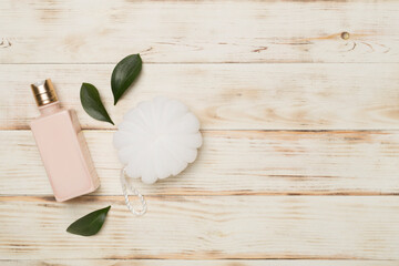 Shower gel with washcloth on wooden background, top view