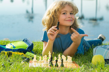 Child playing chess. Clever kid thinking about chess.