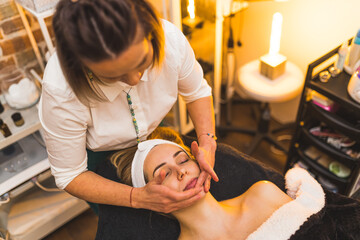 Obraz na płótnie Canvas A woman getting a hand facial spa massage in a beauty salon. High quality photo