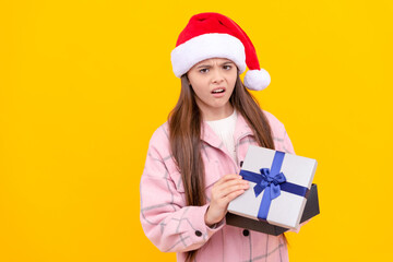 teen girl with gift on yellow background. xmas holiday present. child wearing warm clothes hold box