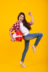 Amazed teenager. Emotional teenager child hold gift on birthday. Funny kid girl holding gift boxes celebrating happy New Year or Christmas. Excited teen girl.