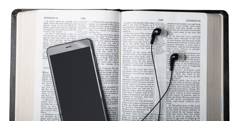 Holy open bible with headphones and mobile phone