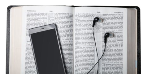 Holy open bible with headphones and mobile phone