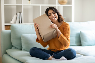 Portrait Of Happy Arab Woman Embracing Cardboard Box With Delivery At Home