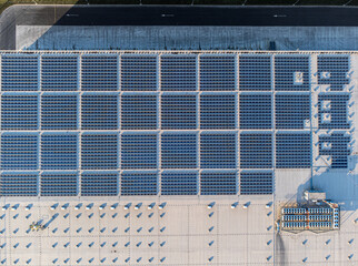 Large solar panel array farm on a commercial distribution warehouse building top down