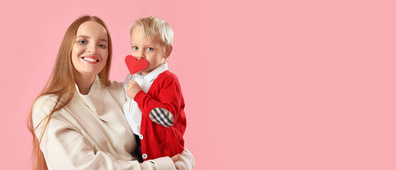 Beautiful young mother and her little son with red heart on pink background with space for text