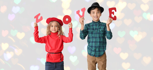 Cute little children with word LOVE on light background. Valentine's Day celebration