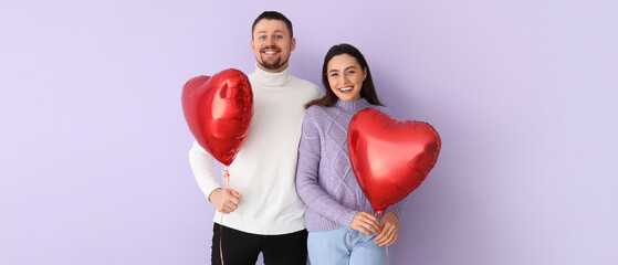 Happy couple with balloons in shape of hearts on lilac background. Valentine's Day celebration