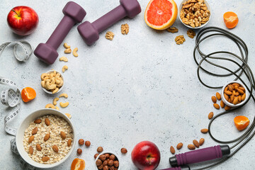 Frame made of delicious healthy food and sports equipment on light background