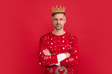 Winter man in crown. Man in holiday sweater and Santa hat on studio background. Christmas sale or special winter offer.