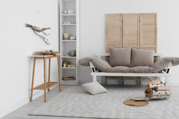 Interior of messy living room with couch and shelving unit