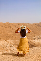 Young woman in desert, back view
