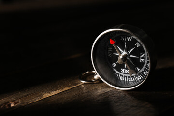 Compass on dark wooden background