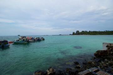 Fototapeta na wymiar Dock, Speed Boat and Beach. This photo was taken on one of the tropical islands in Kotabaru, Indonesia.