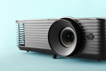 Black video projector on blue background, closeup