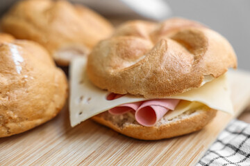 Kaiser rolls with ham and cheese on wooden board - obrazy, fototapety, plakaty