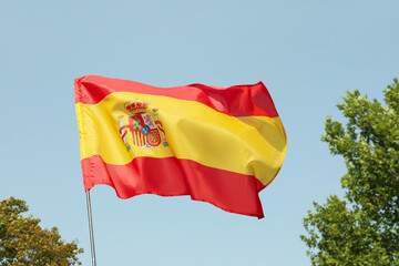 Waving flag of Spain against blue sky