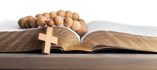 Rosary beads on open bible on wooden table