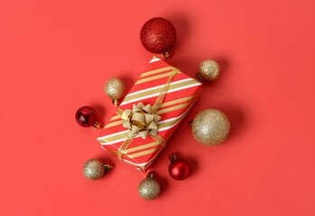 Christmas gift and balls on red background