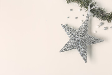 Composition with coniferous branch, Christmas star and balls on light background