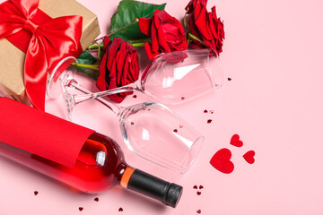 Fototapeta na wymiar Bottle of wine, glasses, roses and gift on pink background. Valentine's Day celebration