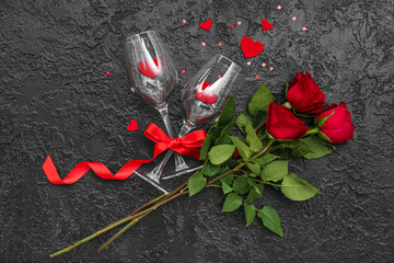 Glasses with hearts and roses on dark background. Valentine's Day celebration