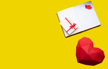 a heart made of cardboard with a notebook and a little gift box