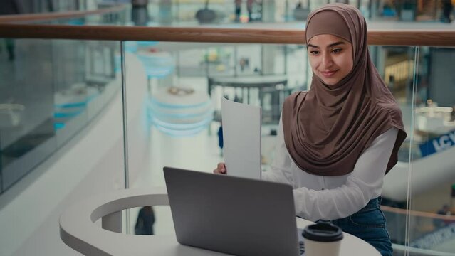 Businesswoman arabian islamic woman in hijab working with business contract paper report documents enter data at computer financial audit distance job paying bills online use banking app e-business