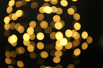Blurred view of beautiful lights on black background. Bokeh effect