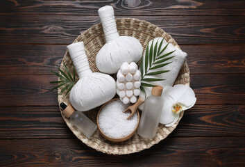 Composition of herbal bags and spa products on wooden table, top view