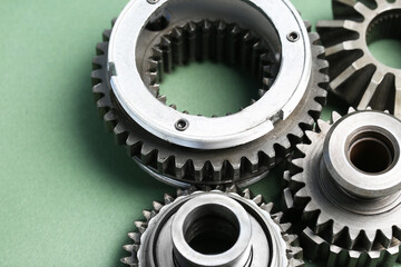 Different stainless steel gears on light green background, closeup