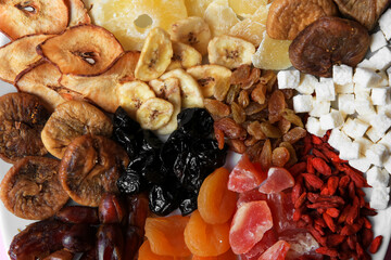 Different dried fruits on plate, top view