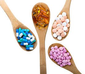Healthy supplements pills on wooden teaspoons