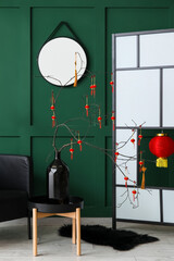 Interior of living room with tree branches in vase and decor for Chinese New Year celebration