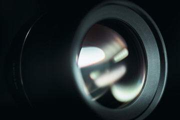 Camera lens with lens reflections and black background. Close up of lens image.
