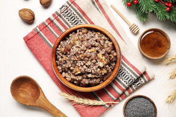 Napkin with bowl of Kutya and ingredients on white background