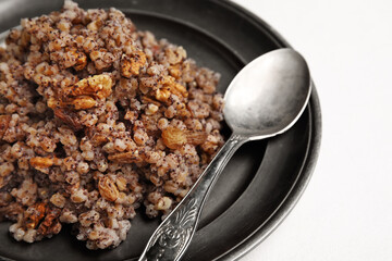 Plate of Kutya and spoon on white background, closeup