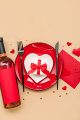 Table setting for Valentine's Day with gift and envelope on beige background