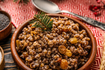 Bowl of Kutya with Christmas branch on napkin, closeup