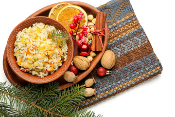 Tray with bowl of rice Kutya, ingredients and Christmas branches on white background