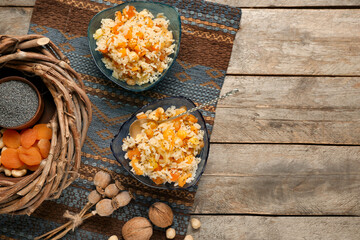 Obraz na płótnie Canvas Bowls of rice Kutya, ingredients and wreath on wooden background