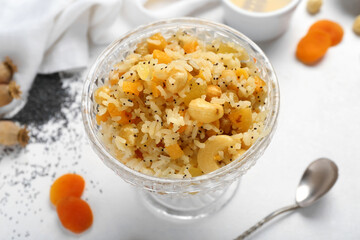 Glass bowl of rice Kutya on white background, closeup