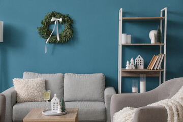 Interior of living room with Christmas wreath, sofa and shelving unit