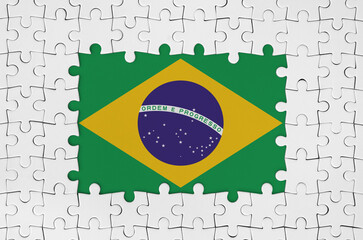 Brazil flag in frame of white puzzle pieces with missing central parts - Powered by Adobe