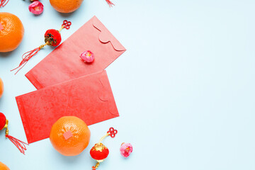 Red envelopes with mandarins and Chinese symbols on blue background. New Year celebration