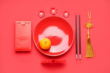 Table setting with envelope and Chinese symbols on red background. New Year celebration
