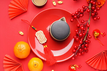 Plate with teapot, mandarins and Chinese symbols on red background. New Year celebration