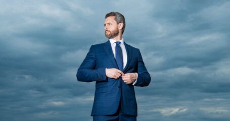 adult man in business suit. photo of man in suit. man in suit on sky background. man in suit outdoor